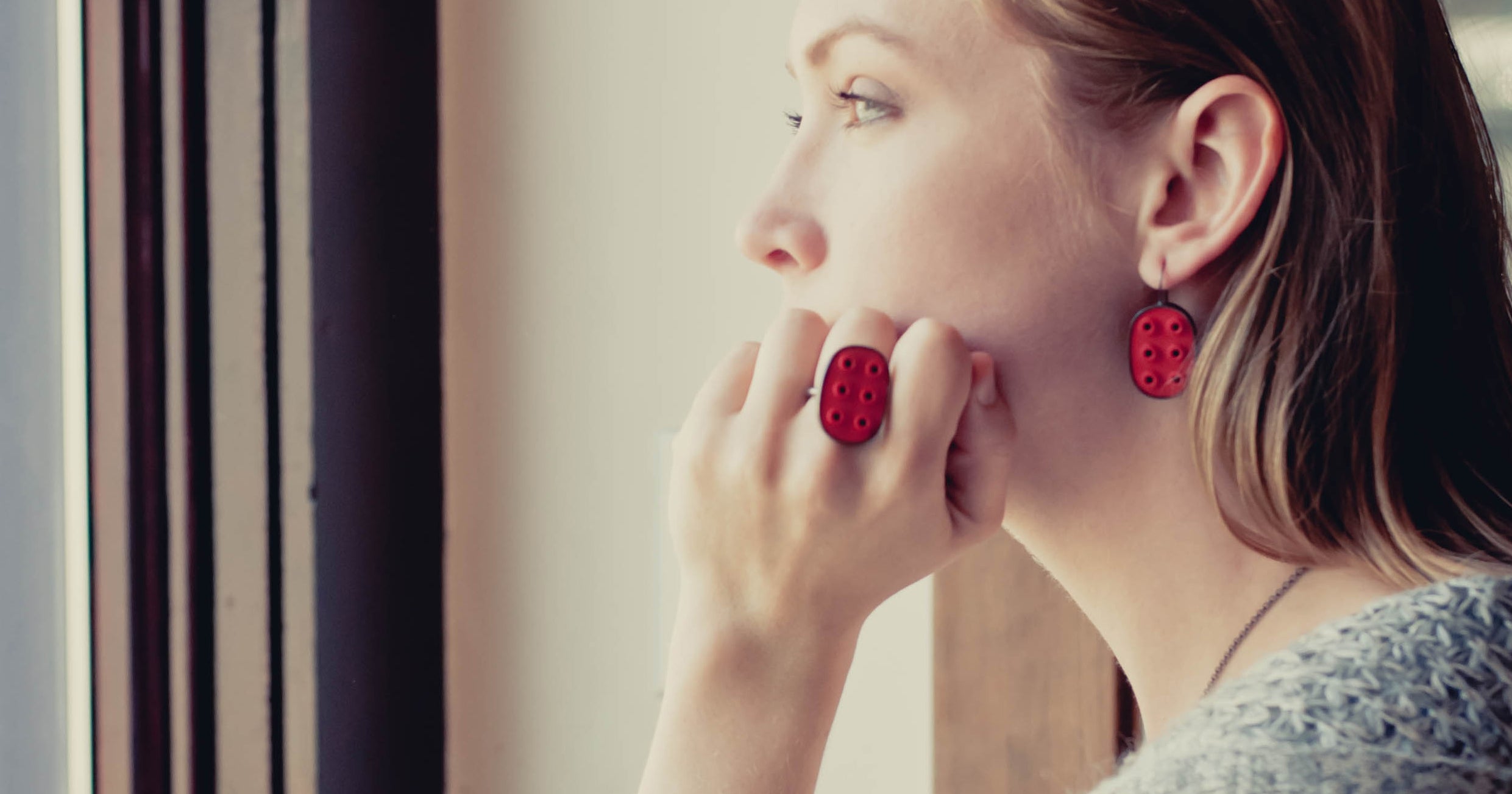 woman with red lego earrings and big ring