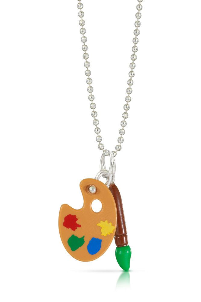 A tiny Lego artist palette with paint colors of red, green, blue, and yellow with a silver loop to go through a chain as a charm with a Lego green paint brush charm beside it