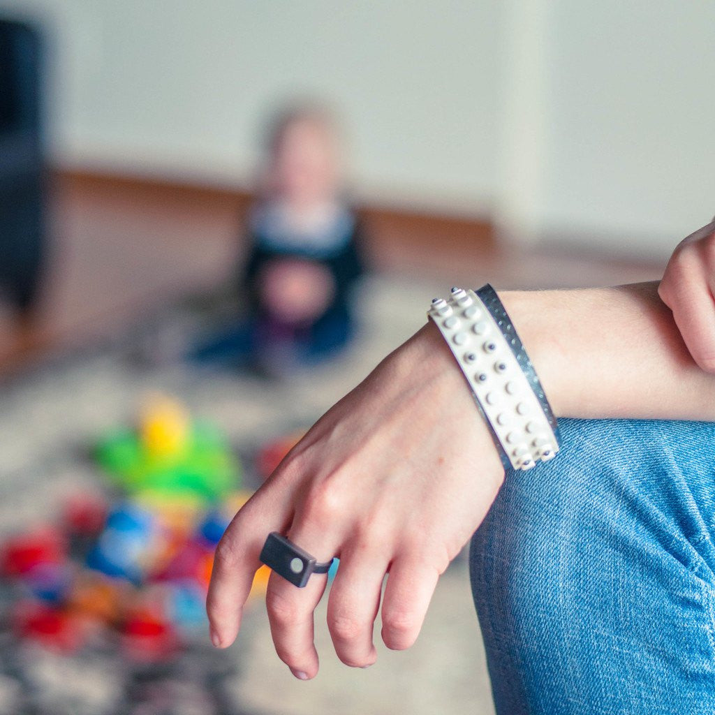 Model wearing modern cuff bracelet made from sterling silver and white base plate LEGO.