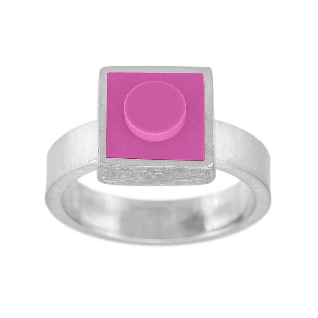 Hot pink 1 X 1 square LEGO inset into metal on top of a ring