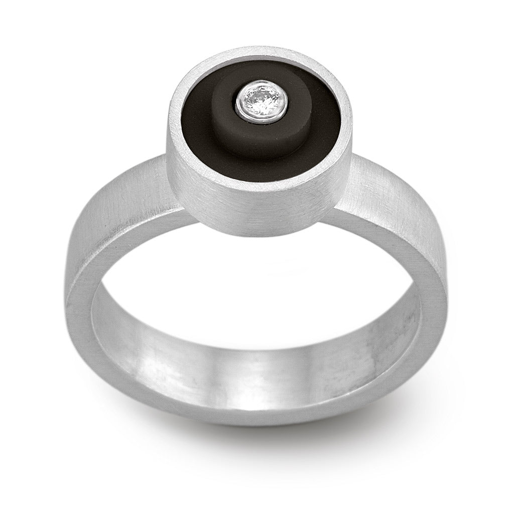 Black LEGO ring with a LEGO dot on top, set in sterling silver with a diamond in the middle on a band with a matte finish