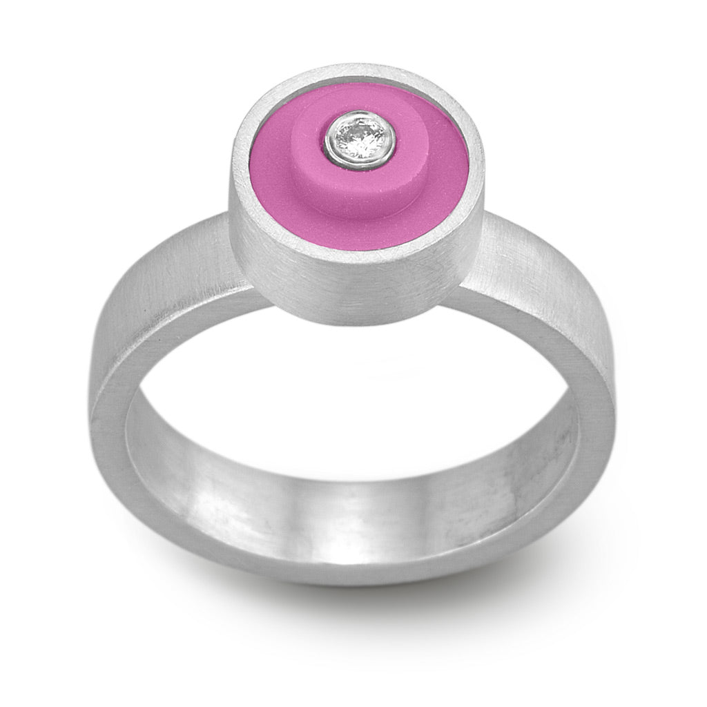 Ring with a hot pink round lego dot on top with a diamond set into the center
