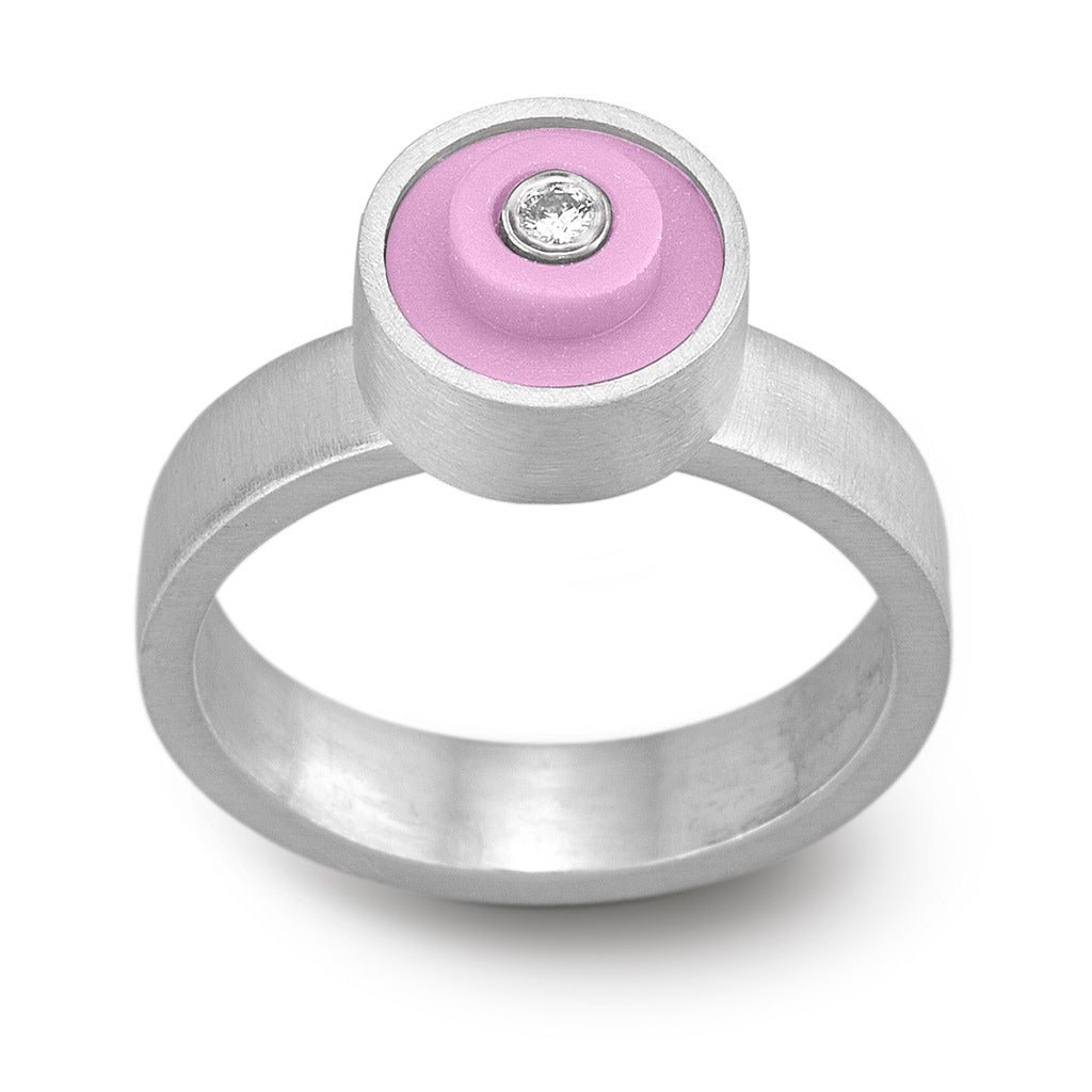 Ring with a light pink round lego dot on top with a diamond set into the center