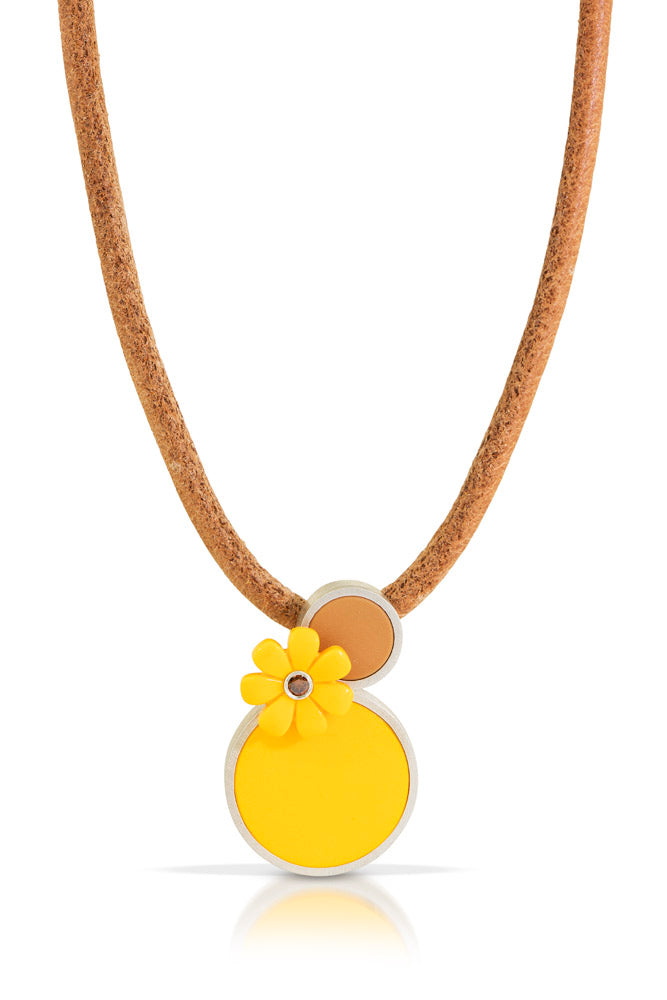 a pendant that has. 2 lego dots one small light brown, one large yellow with a yellow lego daisy juxtaposed with a brown diamond in center on a leather cord