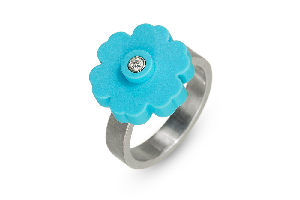a sterling silver ring with a turquoise LEGO flower piece on top with a diamond set in the middle