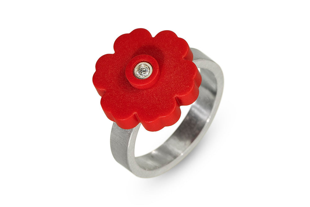a sterling silver ring with a red LEGO flower piece on top with a diamond set in the middle
