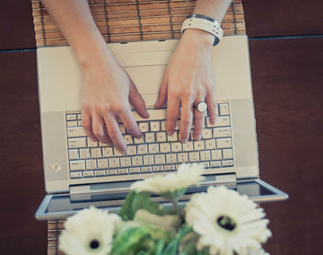 LEGO modern art jewelry blog. Model typing on computer wearing a white LEGO  brick ring and a white flat plate LEGO bangle bracelet 