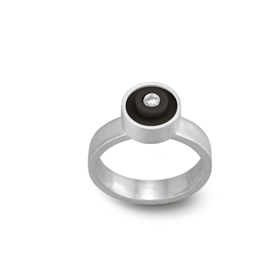 Ring with a black round lego dot on top with a diamond set into the center