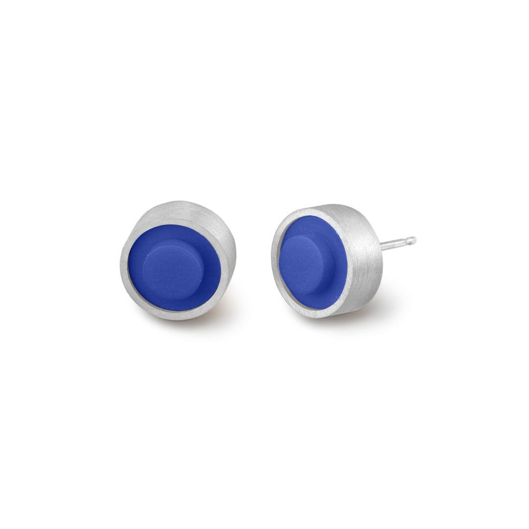 Pair of round blue LEGO dot earrings set into silver on a white background