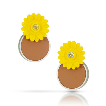 Yellow plastic sunflower with a yellow diamond set in the center with silver around it. Sunflower is positioned over a light brown circle 