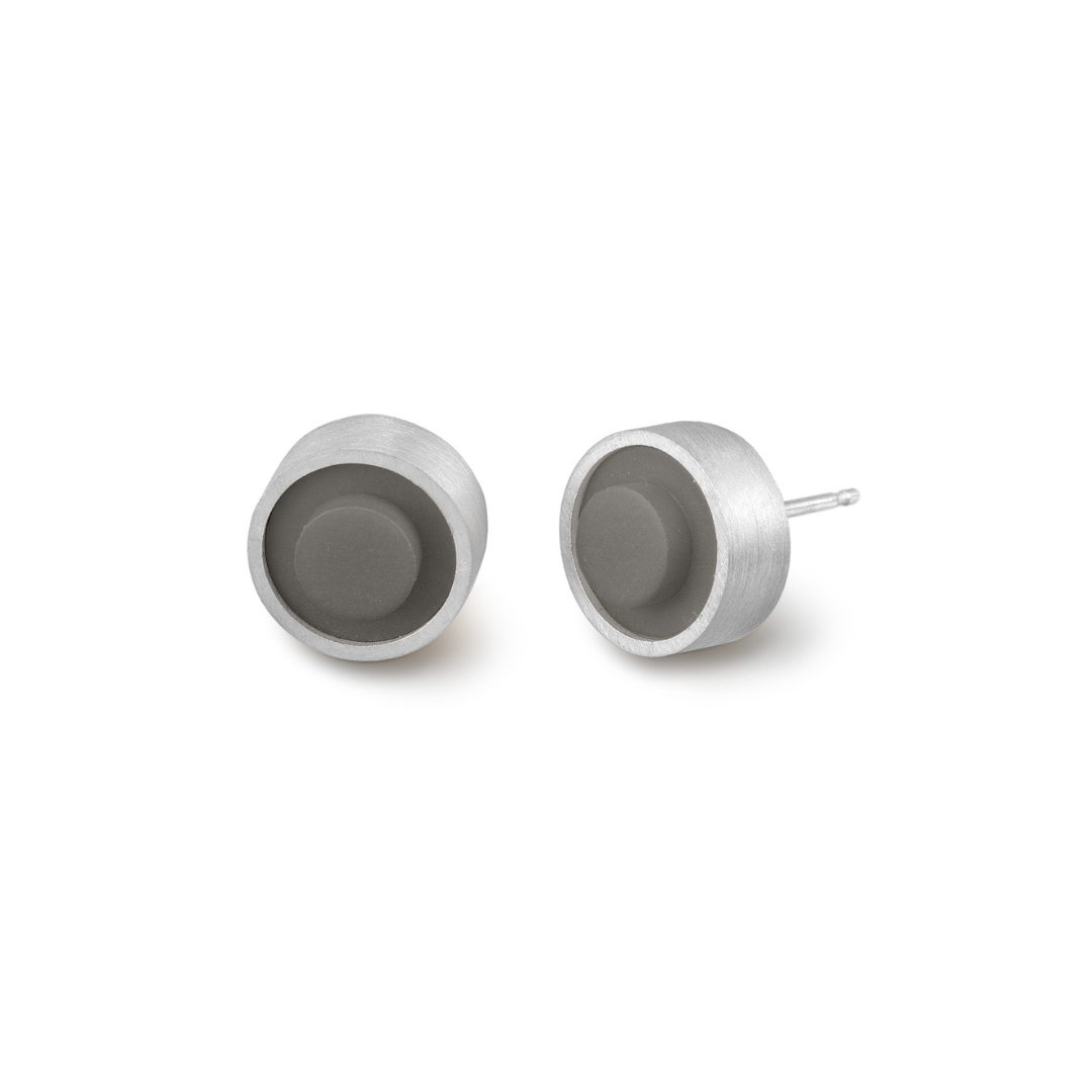 Pair of round grey LEGO dot earrings set into silver on a white background
