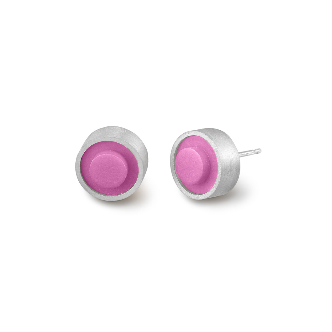 Pair of round pink LEGO dot earrings set into silver on a white background