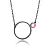 a necklace with a dark finish on the metal with a large circle pedant in center with a small circle attached to the side with a dark pink recycled piece of a lego tube inside the small circle