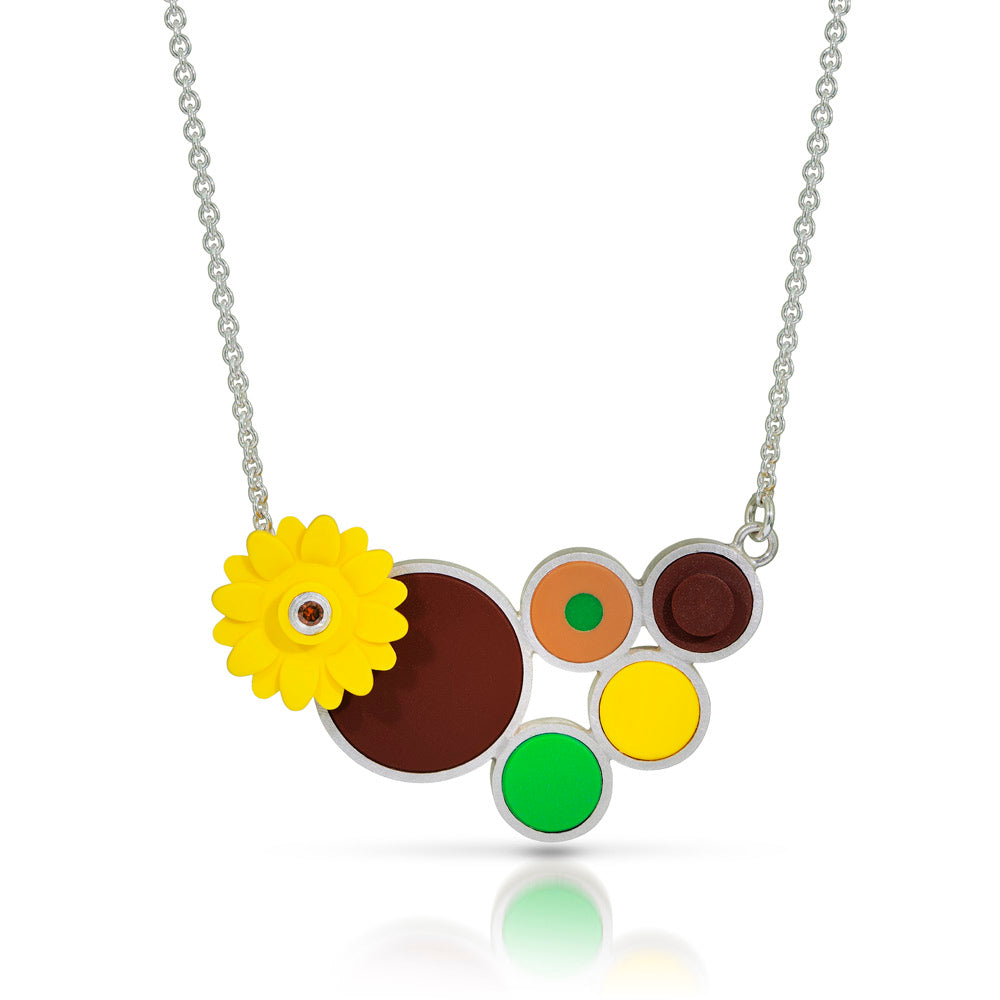 Yellow LEGO sunflower  piece with a diamond in the center attached to a chain with colorful dots arranged in a modern style in the colors of van gogh's sunflower paintings.