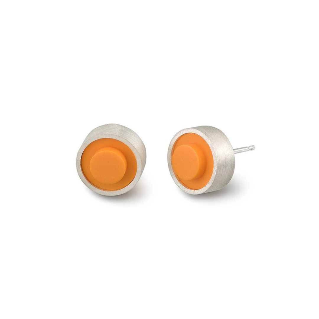 Pair of round orange LEGO dot earrings set into silver on a white background