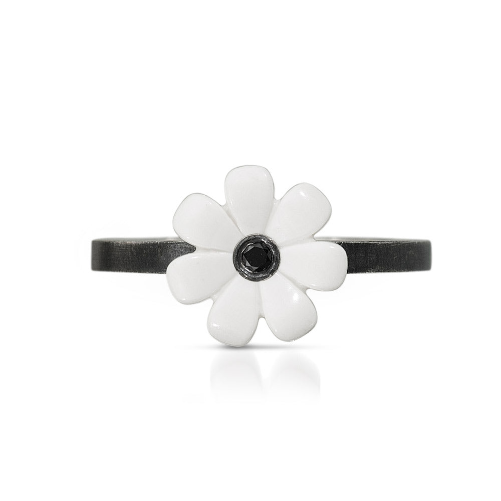 oxidized sterling silver band with a white lego flower on top with a black diamond set into the center.