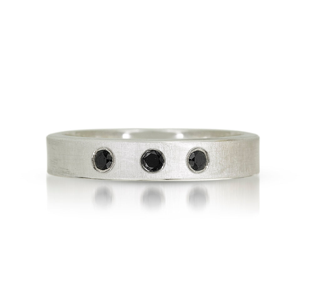sterling silver band with a satin finish and 3 black diamonds set flush into the silver