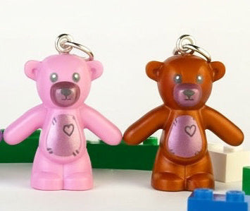 Colorful teddy bear charms with building block toys on a white background