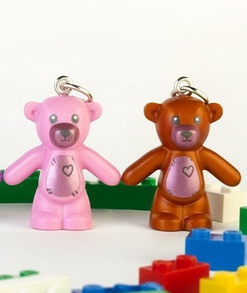 Colorful teddy bear charms with building block toys on a white background
