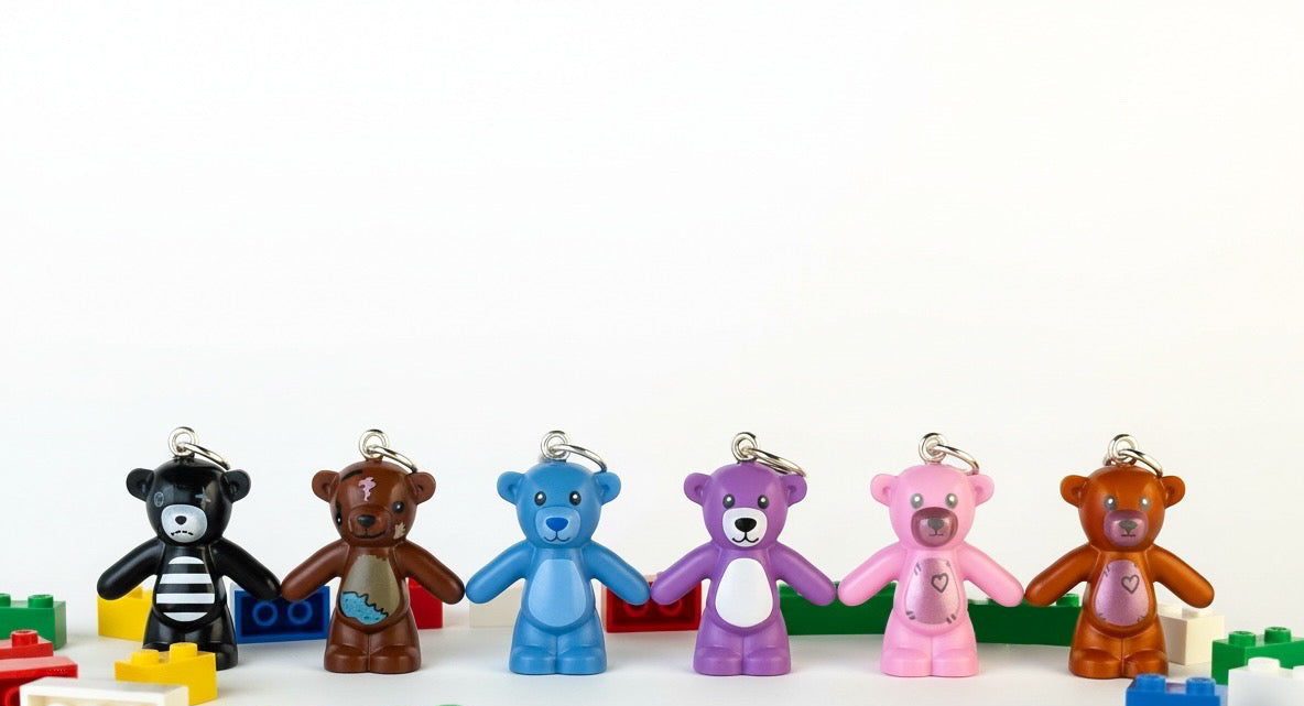 Colorful teddy bear charms with building block toys on a white background