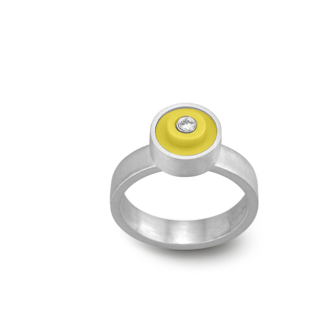 Sterling silver ring with a yellow round lego dot on top with a diamond set into the center