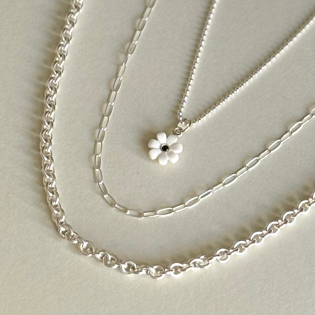 Chunky size rings that interlock with each other to create a chain. Shown how it would look laying around the neck