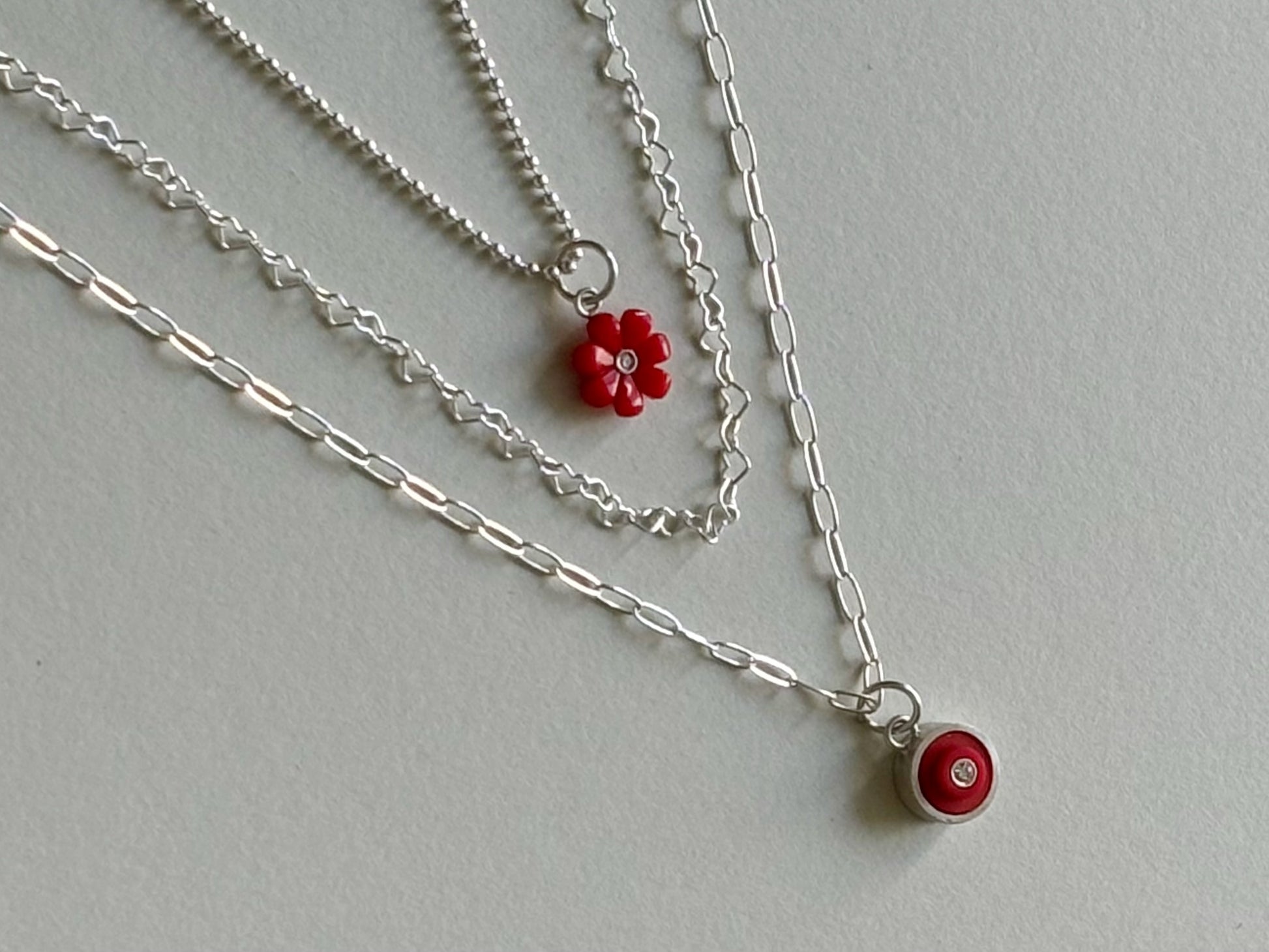 3 necklaces displayed layering together to show how they would look styled together around a neck with the heart chain in between them
