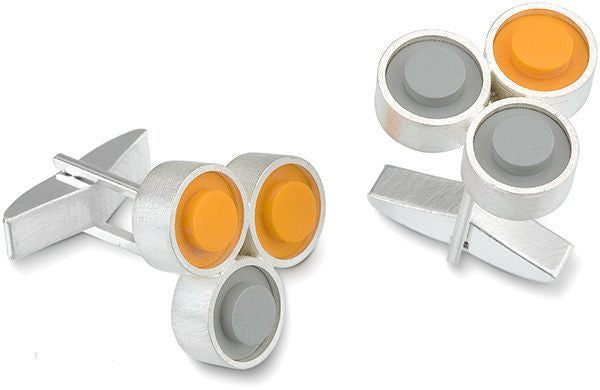A pair of sterling silver cufflinks with orange and grey LEGO studs