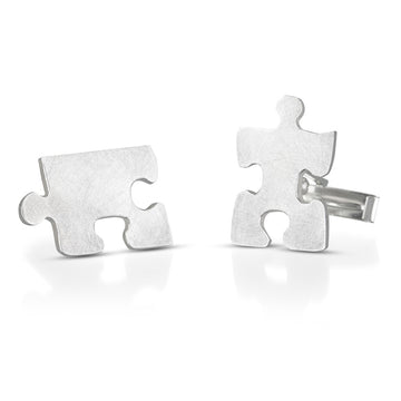 cuff links in the shape of puzzle pieces that fit together, but shown apart